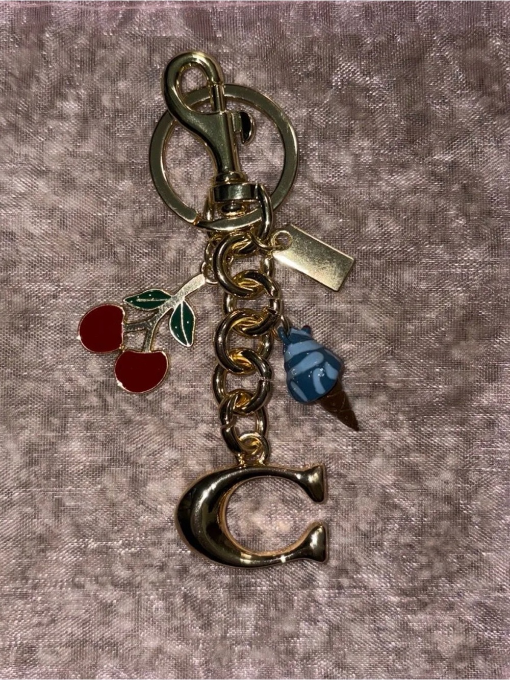 Gold Coach Bag Charm/Keychain with a Cherry & a Blue Ice Cream Charm.